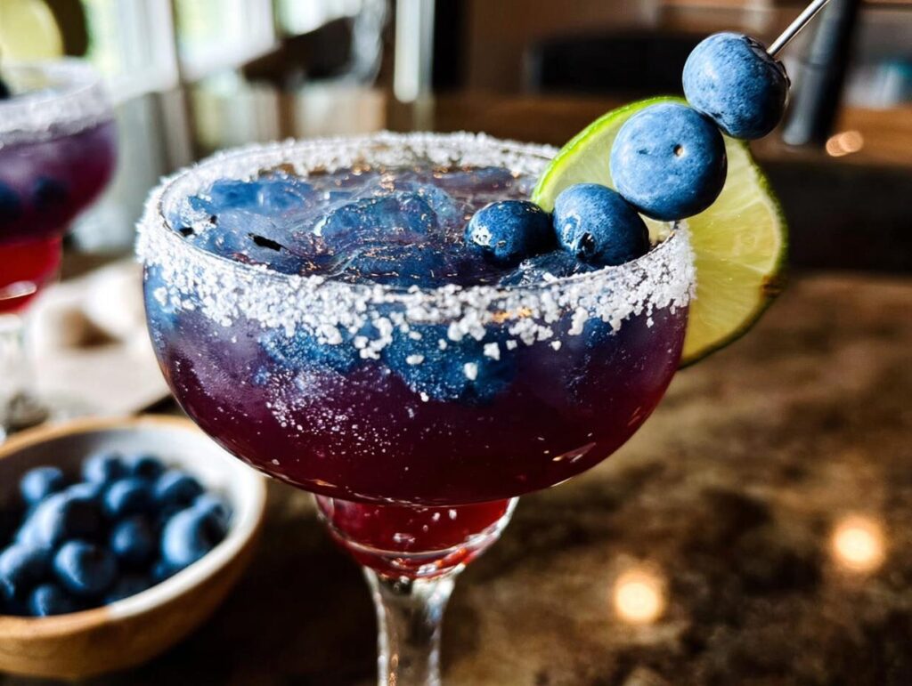 A refreshing blueberry Thanksgiving drink garnished with fresh blueberries and a lime slice.