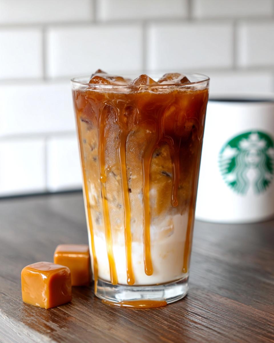 A tall glass of Café-Style Iced Caramel Macchiato copycat with rich caramel drizzle over ice and milk.