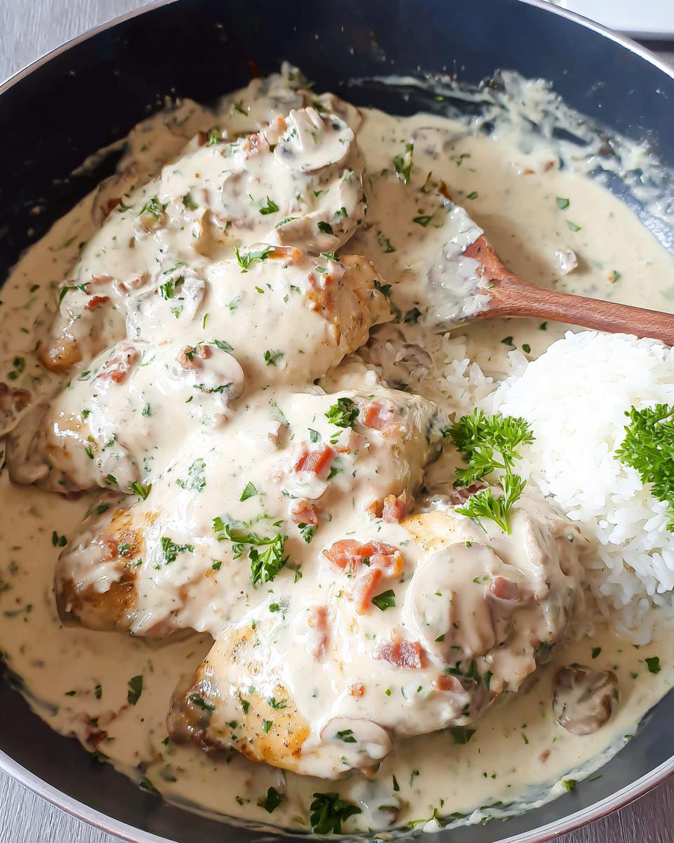 Four pieces of chicken smothered in a creamy mushroom sauce served with white rice for a Creamy Smothered Chicken and Rice Recipe.