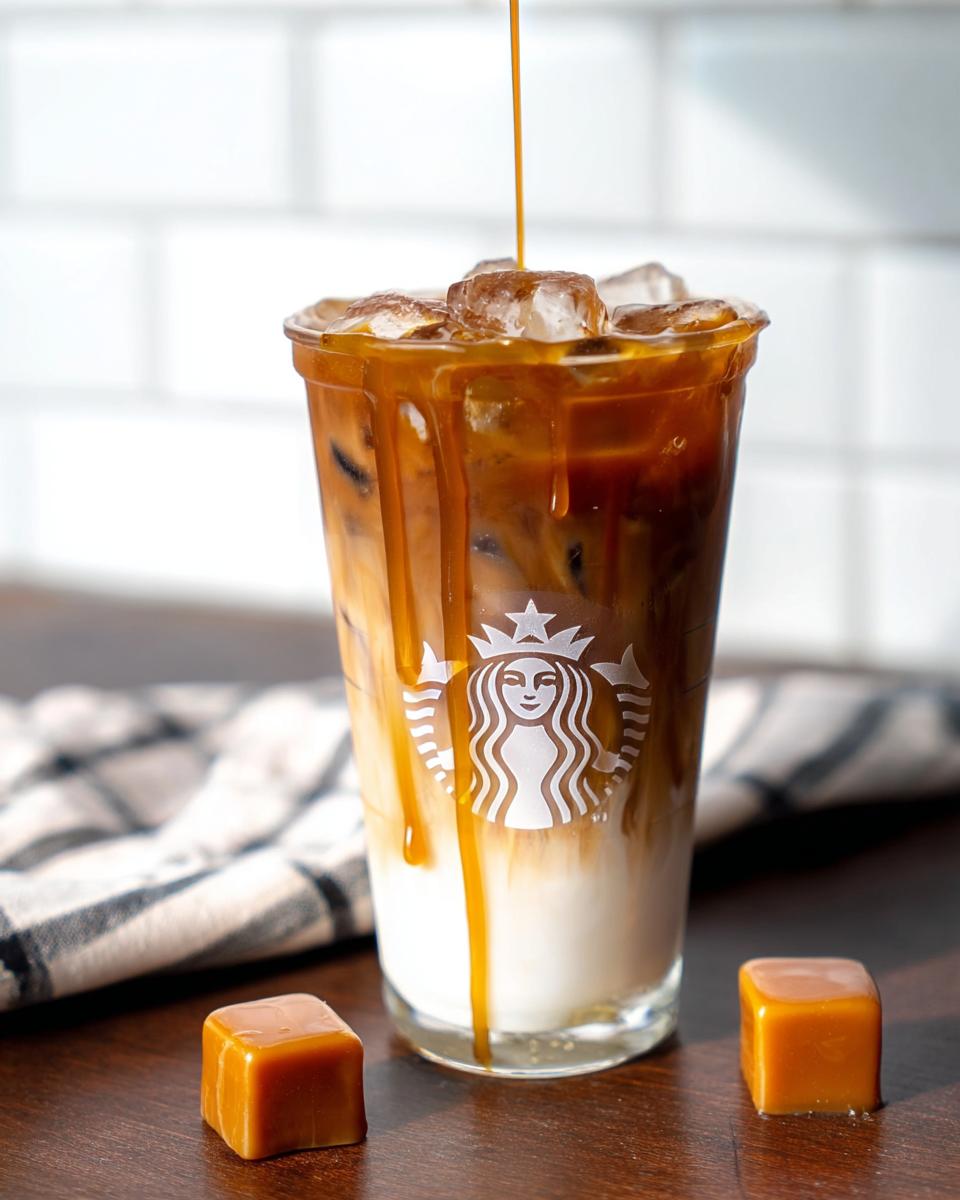 Caramel being drizzled over an iced Café-Style Iced Caramel Macchiato copycat in a glass.
