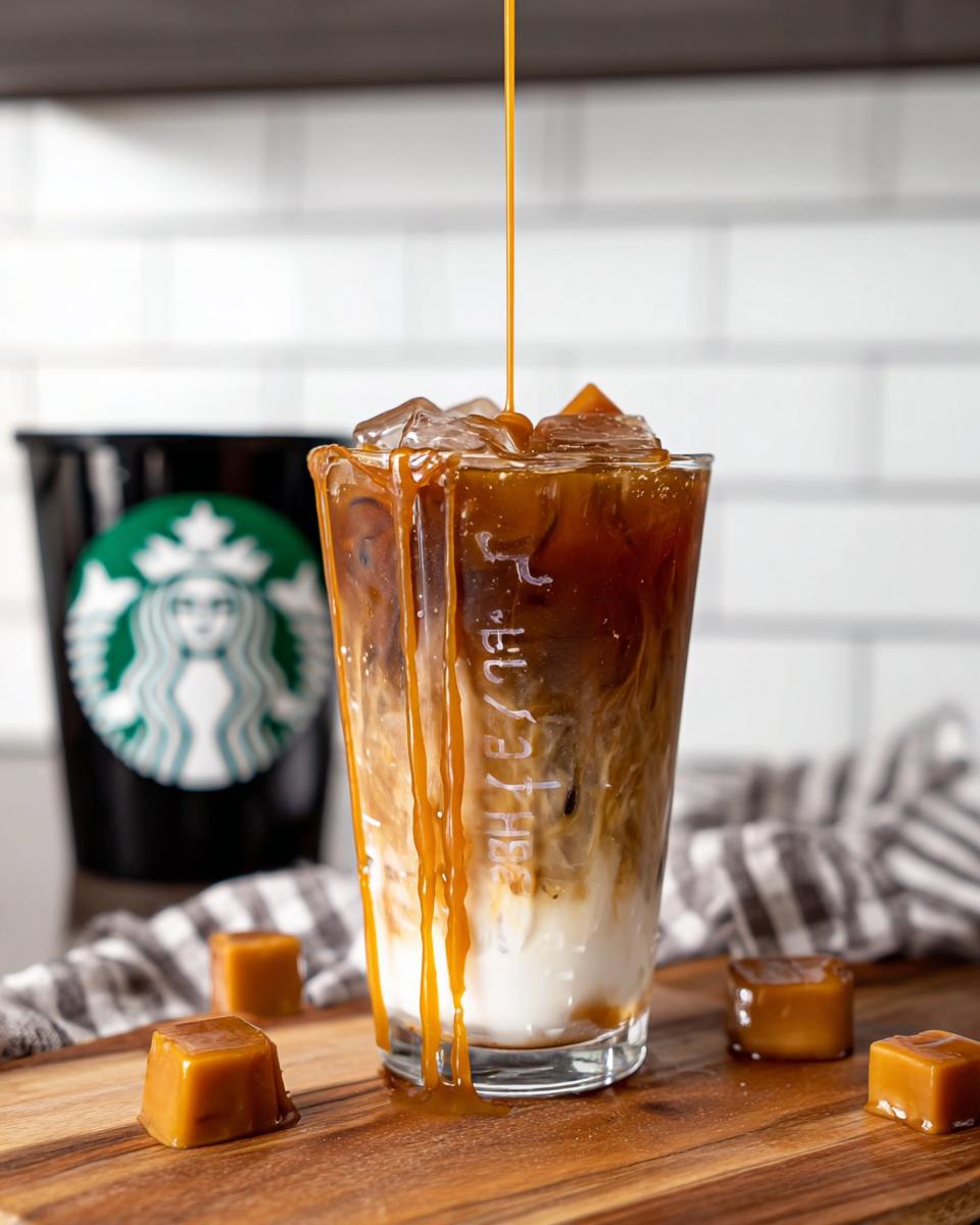 Caramel syrup being drizzled over a layered Café-Style Iced Caramel Macchiato copycat drink.
