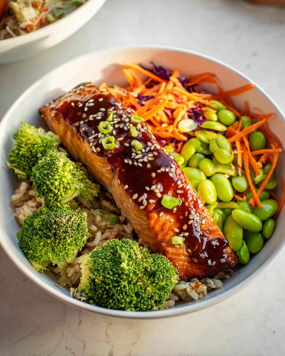 Close-up of a Healthy Teriyaki Salmon and Broccoli Bowl with glazed salmon, brown rice, broccoli, edamame, and carrots.