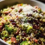 Close-up of a vibrant broccoli and cranberry quinoa salad, topped with grated cheese, a perfect veggie side.