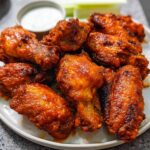 A plate piled high with crispy, saucy chicken wings, perfect for any party or game day.