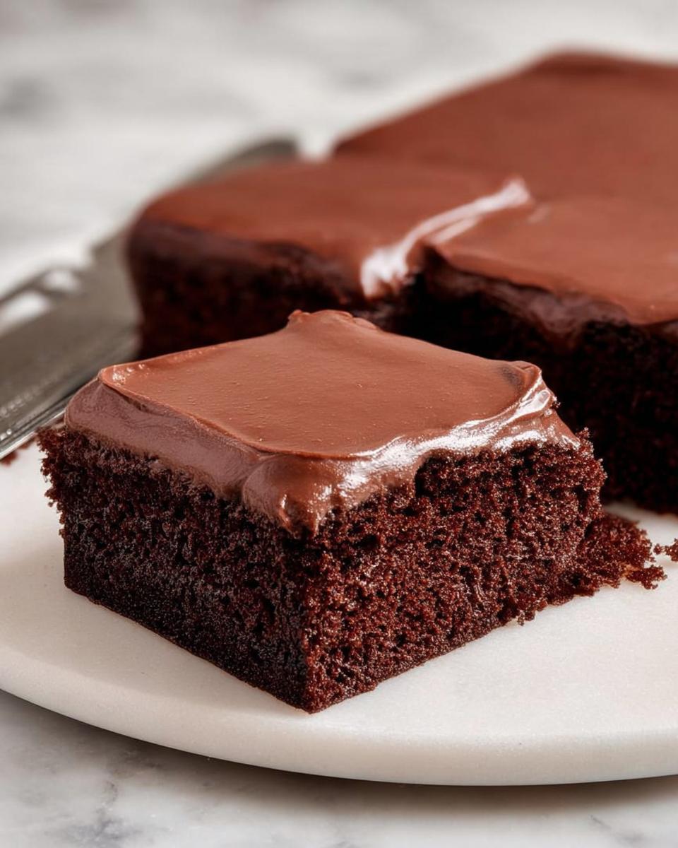 A decadent slice of chocolate cake with rich chocolate frosting, showcasing its moist crumb and delicious cake ideas.