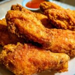 Close-up of golden brown, crispy fried chicken wings, part of the ultimate chicken wings recipes guide for beginners.