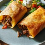 Two golden-brown burritos filled with seasoned beef and vegetables, part of easy dinner recipes.