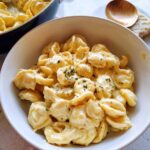 A bowl of creamy pasta with herbs, demonstrating how to make easy dinner recipes like a pro.