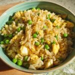 A close-up of a bowl of simple egg fried rice with peas, a perfect example of 7-Ingredient Egg Recipes.