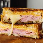 A delicious ham and cheese sandwich with melted cheese oozing out, perfect for sandwich ideas recipes.