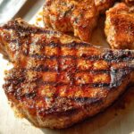 Close-up of perfectly grilled pork chops, showcasing grill marks and a flavorful crust. This recipe delivers juicy pork chops.