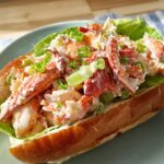 A delicious lobster roll sandwich filled with lobster salad, lettuce, and green onions, part of The Ultimate Sandwich Ideas Recipes Guide.