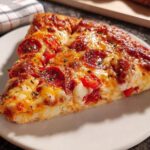 A delicious slice of pepperoni pizza, perfect for Pizza Night Recipes Meal Prep, with melted cheese and crispy pepperoni.