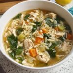 A close-up of a bowl of restaurant-style chicken orzo soup with vegetables, a perfect addition to your restaurant-style soup recipes at home.