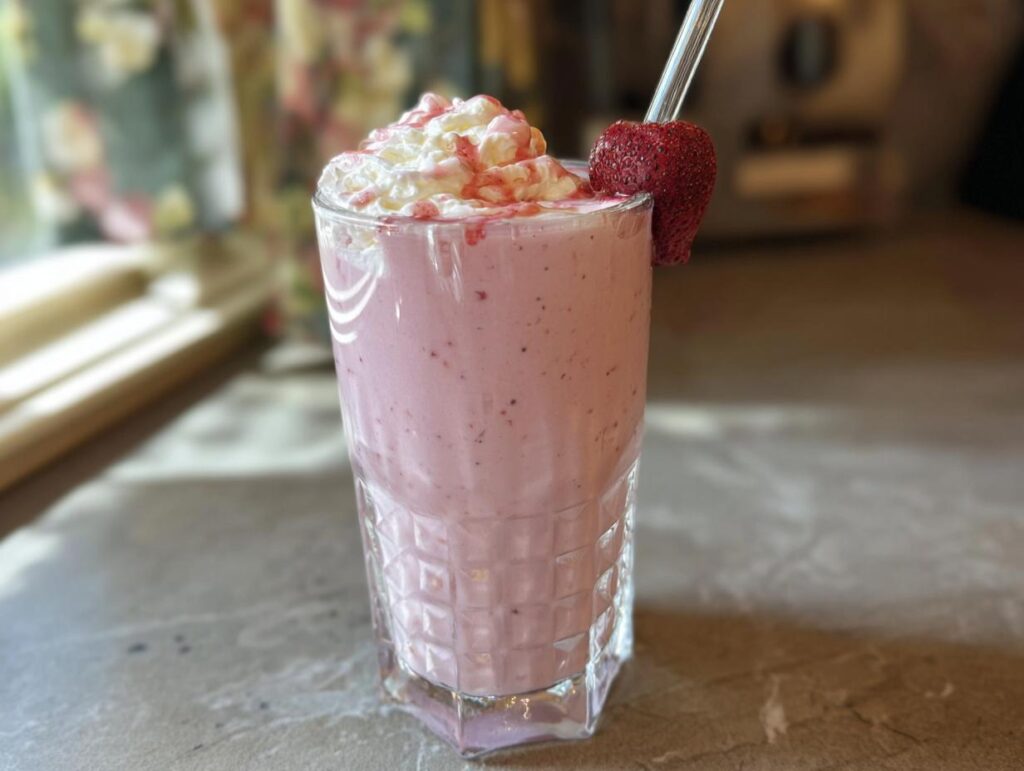 A refreshing strawberry smoothie with whipped cream and a fresh strawberry garnish, perfect for when you crave Starbucks drinks.