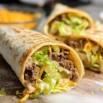 Close-up of two Homemade Big Mac Wraps filled with seasoned ground beef, shredded lettuce, cheese, and sauce.