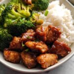 A delicious Honey Garlic Pork Rice Bowl featuring tender pork pieces, fluffy white rice, and roasted broccoli.