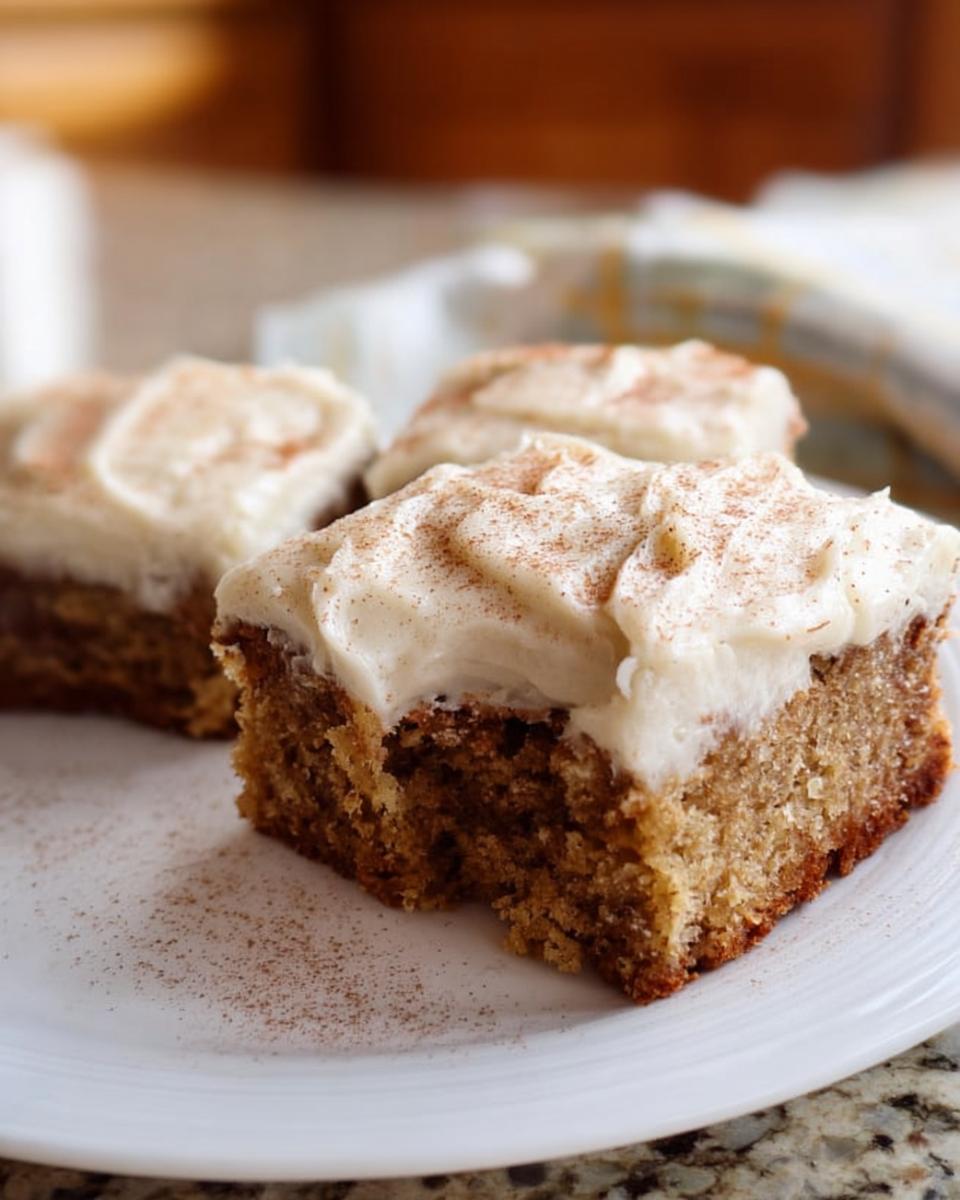 Close-up of a slice of Banana Bread Brownies Made Easy, topped with creamy frosting and dusted with cinnamon.