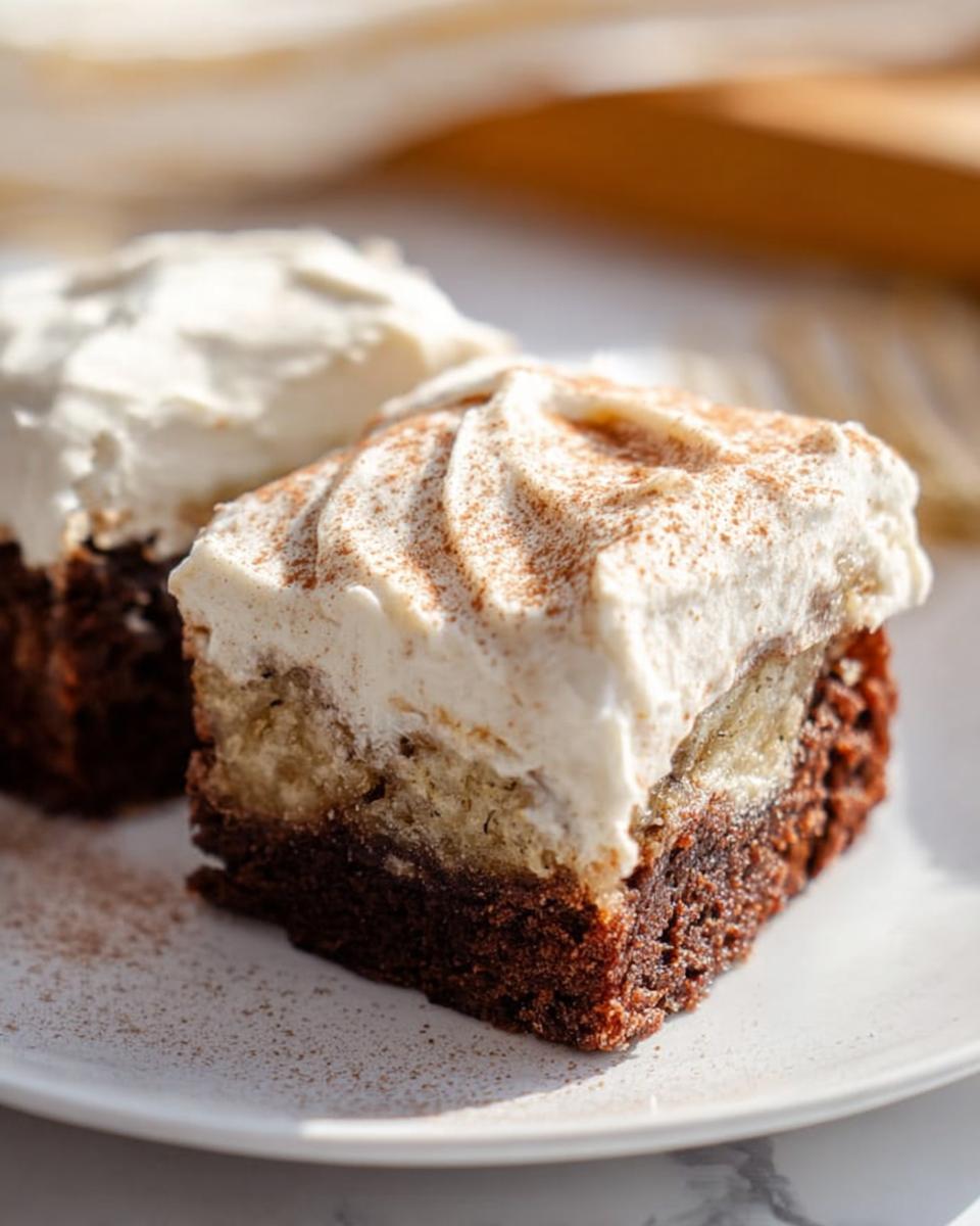 Two slices of Banana Bread Brownies Made Easy topped with creamy frosting and cinnamon.
