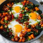 A hearty one-pan BREAKFAST SWEET POTATO hash with fried eggs, bacon, kale, and green onions.
