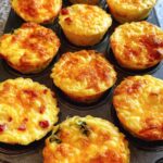 Golden brown Cheesy Muffin Tin Cottage Cheese Egg Bites baked in a muffin tin, topped with melted cheese.