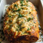 Golden baked Chicken Avocado Ranch Burritos topped with melted cheese and fresh parsley in a baking dish.
