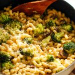 Close-up of Healthy One Pot Broccoli Mac & Cheese in a pan with a wooden spoon.