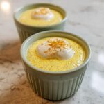 Two servings of bright yellow Lemon Cream Chia Pudding topped with whipped cream and a sprinkle of zest.