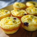 Close-up of golden-brown Blueberry and Lemon Zest Cottage Cheese Bites topped with lemon zest and parsley.