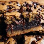 Close-up of a decadent Brown Butter Brookie, showing layers of chewy cookie and rich brownie with melted chocolate chips.