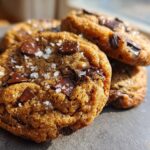 Close-up of freshly baked brown butter chocolate chip cookies sprinkled with sea salt.