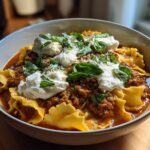 A bowl of comforting Classic Lasagna Soup with pasta, rich meat sauce, dollops of ricotta, and fresh basil.