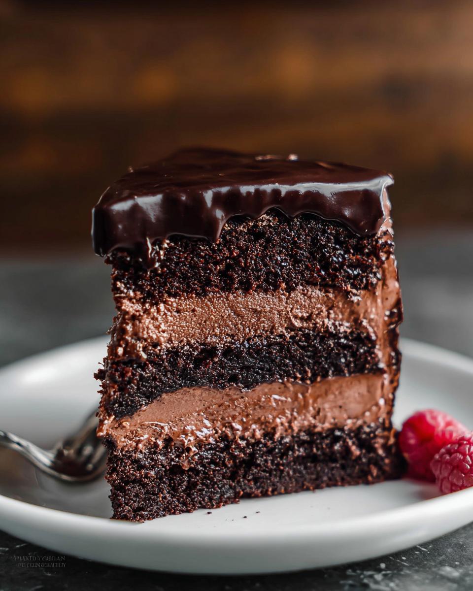 A decadent slice of Dark Chocolate Mousse Cake with rich chocolate layers and glossy ganache topping.