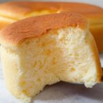 A slice of fluffy Japanese cotton cheesecake cupcake being lifted by a server, showing its airy texture.
