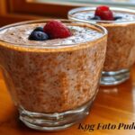 Two glasses of creamy Low Carb Protein Pudding topped with fresh raspberries and blueberries.