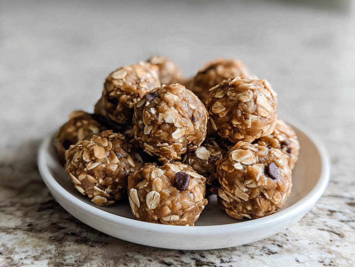 A white bowl filled with delicious no-bake chocolate peanut butter protein balls, showing oats and chocolate chips.